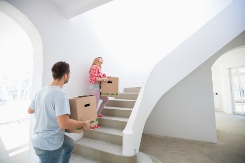 Local movers handling boxes and furniture in a Deptford street